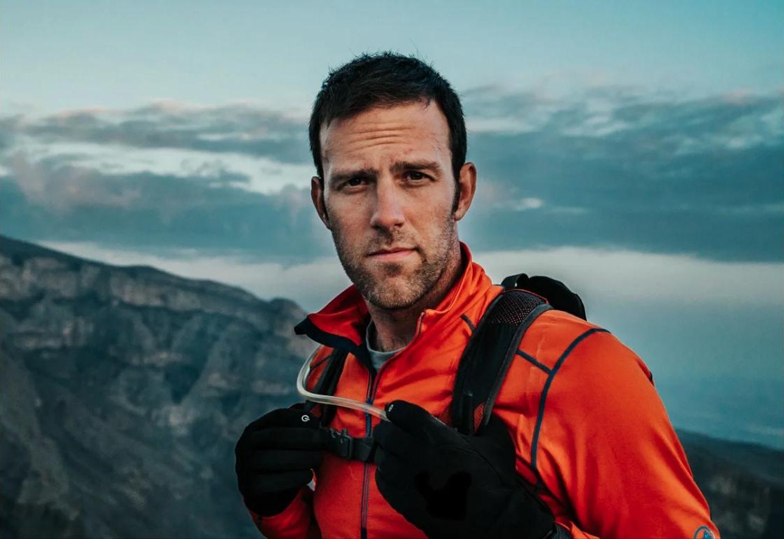 Ryan Pyle on a ridge above a valley at dusk