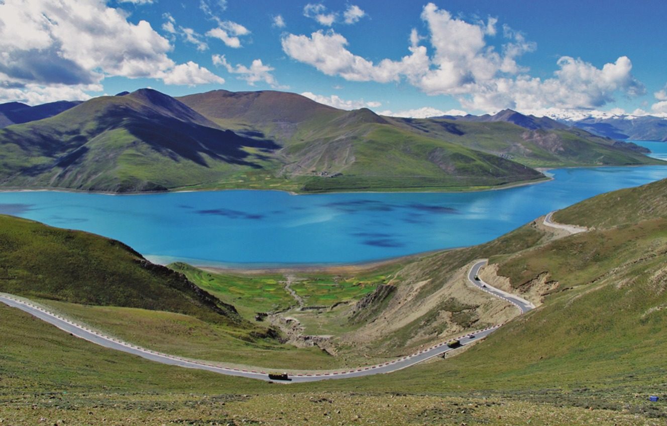A mountain road above a lake on the Tibetan Plateau